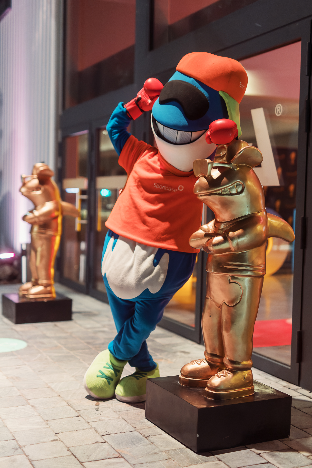 Mascotte (orca) leunt tegen de gouden awardbeeldjes